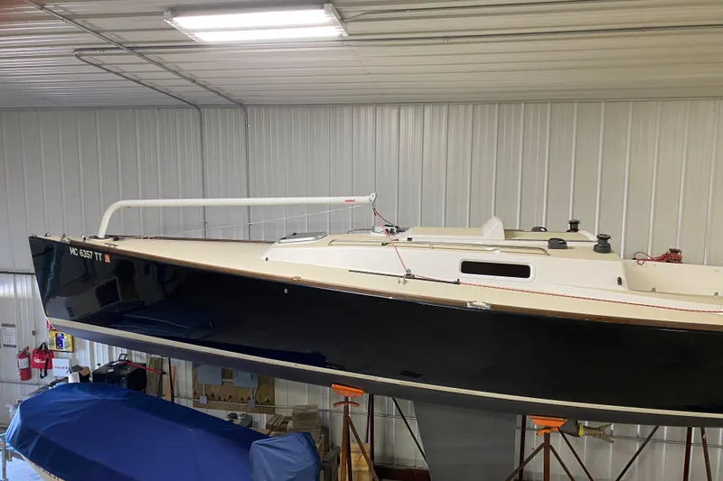 Slide: The Image of 2014 J Boats J/100 sailboat in storage, black hull, indoor facility. - 6