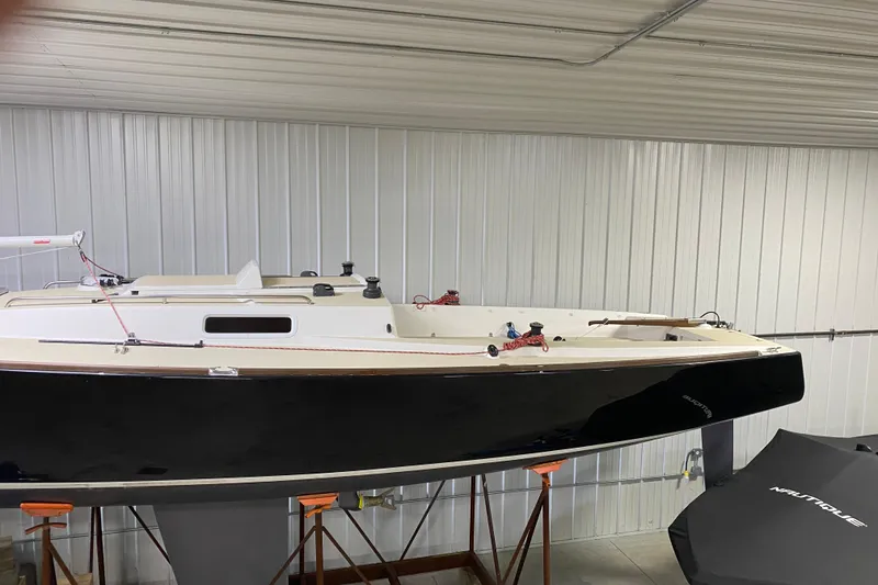 Slide: The Image of 2014 J Boats J/100 sailboat in indoor storage, sleek black hull, white deck. - 7
