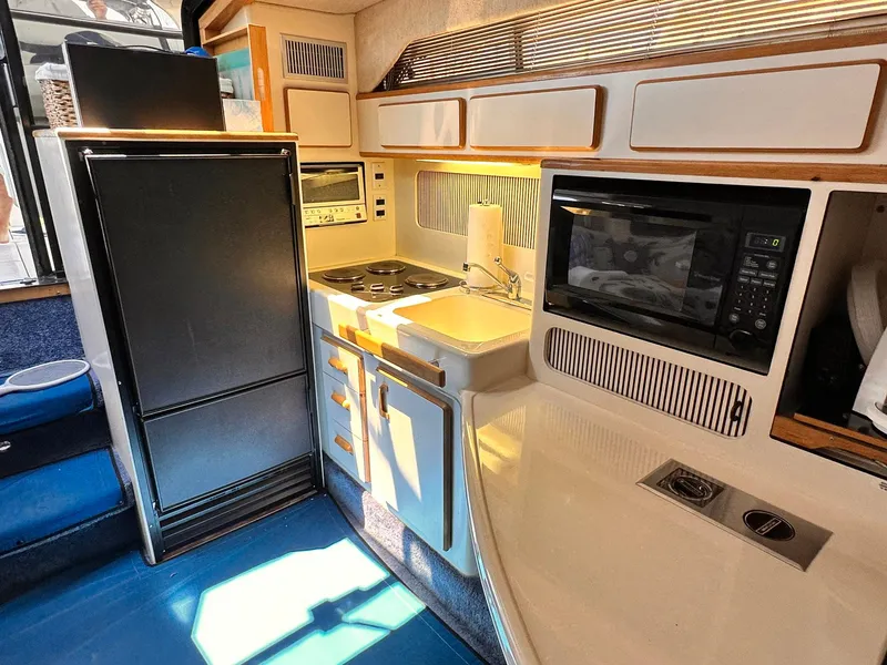 Slide: The Image of 1992 Sea Ray 400 Express Cruiser kitchen with appliances and storage cabinets. - 12