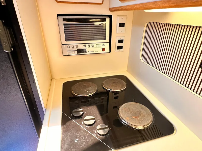 Slide: The Image of 1992 Sea Ray 400 Express Cruiser kitchen with stove and built-in microwave. - 14