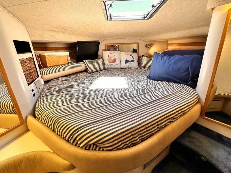 Slide: The Image of Cozy cabin interior of 1992 Sea Ray 400 Express Cruiser with striped bedding and skylight. - 15