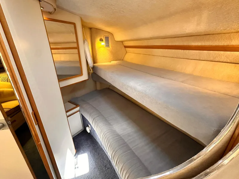 Slide: The Image of 1992 Sea Ray 400 Express Cruiser cabin with bunk beds and cozy lighting. - 16