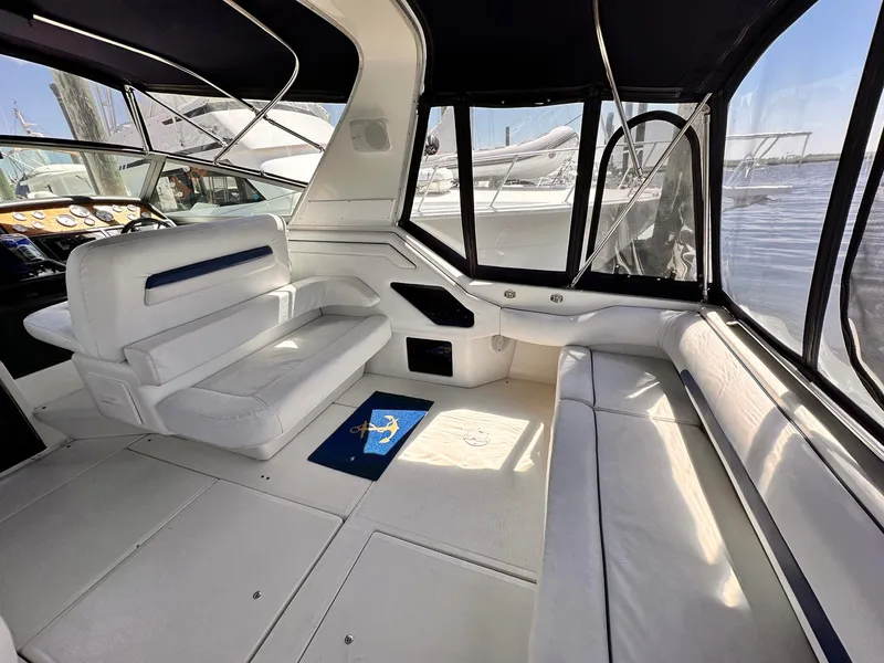 Slide: The Image of Interior of a 1992 Sea Ray 400 Express Cruiser with white seating and windows. - 3