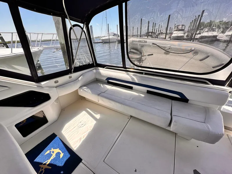 Slide: The Image of 1992 Sea Ray 400 Express Cruiser interior with white seating, marina view, and nautical-themed decor. - 4