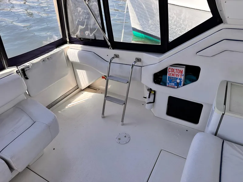 Slide: The Image of Interior of 1992 Sea Ray 400 Express Cruiser with white seating and ladder. - 5