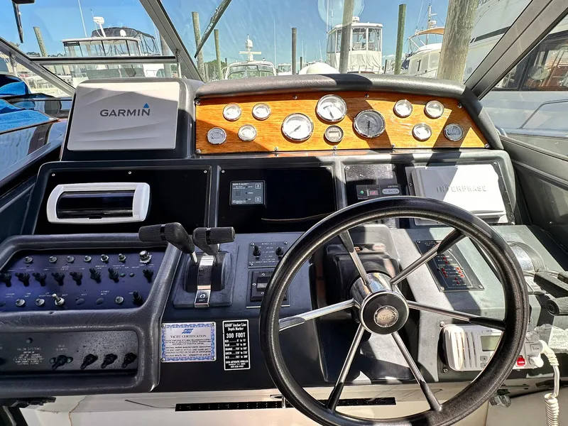 Slide: The Image of 1992 Sea Ray 400 Express Cruiser helm with Garmin navigation and classic wooden dashboard. - 8