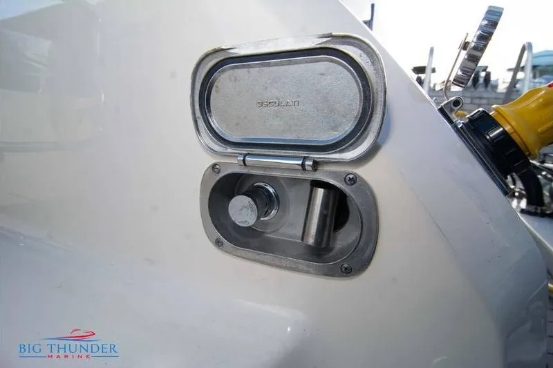 Slide: The Image of Fuel cap of 2022 Scout 350 LXZ boat, featuring a metallic cover and marine branding. - 21