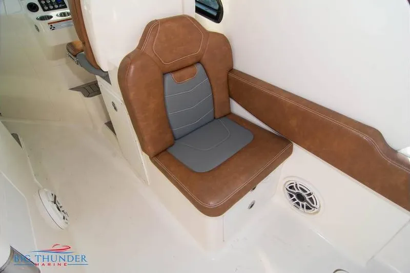 Slide: The Image of 2022 Scout 350 LXZ boat interior with brown and gray seating, speaker, and control panel. - 32