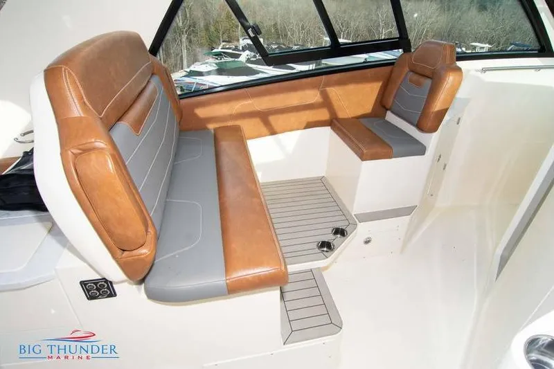 Slide: The Image of 2022 Scout 350 LXZ boat interior with brown and gray seating, large windows. - 49