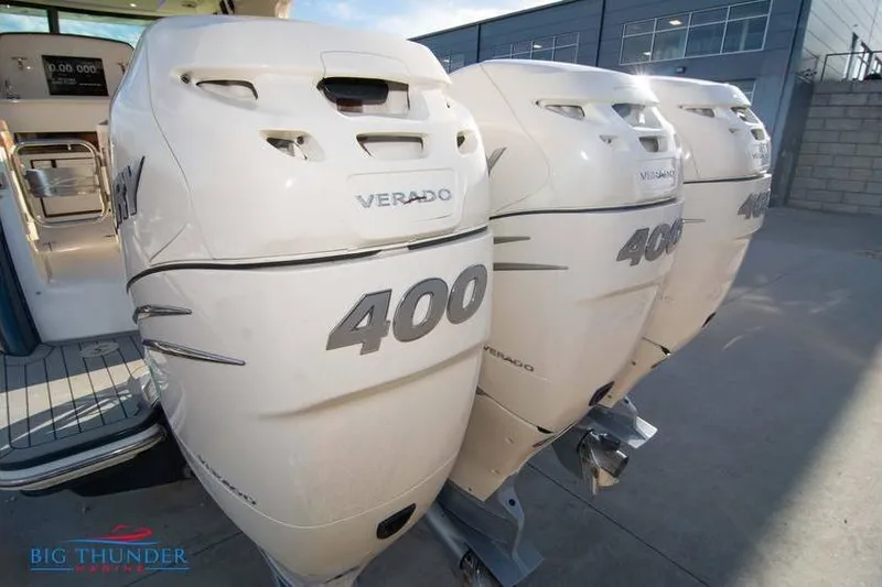 Slide: The Image of 2022 Scout 350 LXZ with triple 400 Verado outboard engines at a marina. - 6