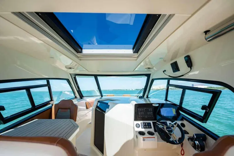 Slide: The Image of Manufacturer Provided Image: Interior view of 2022 Scout 350 LXZ boat with modern dashboard and panoramic windows. - 77