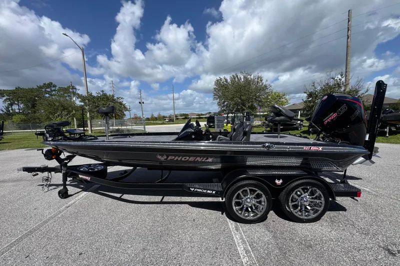 Slide: The Image of 2026 Phoenix 921 Elite X boat on trailer under a cloudy sky. - 2
