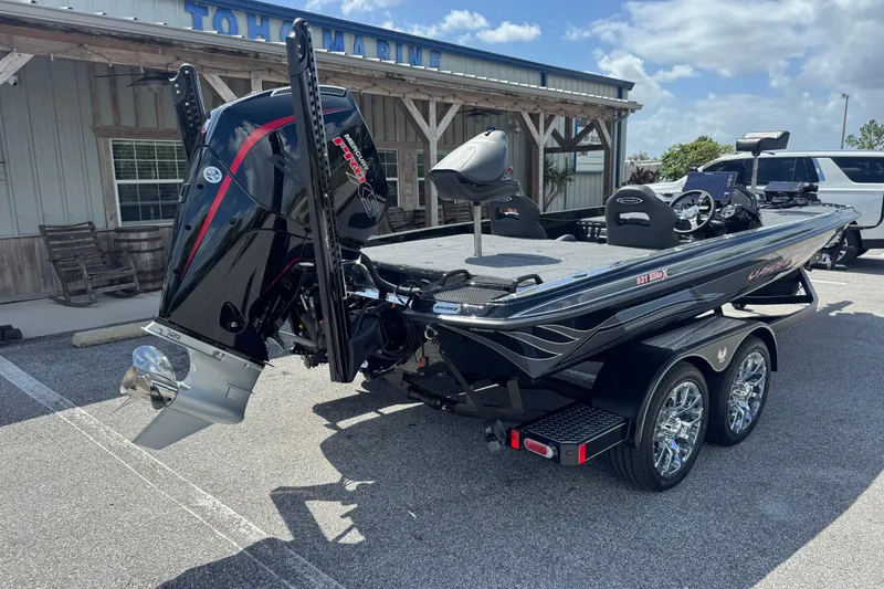 Slide: The Image of 2026 Phoenix 921 Elite X boat with powerful outboard motor, parked outside a marina. - 7