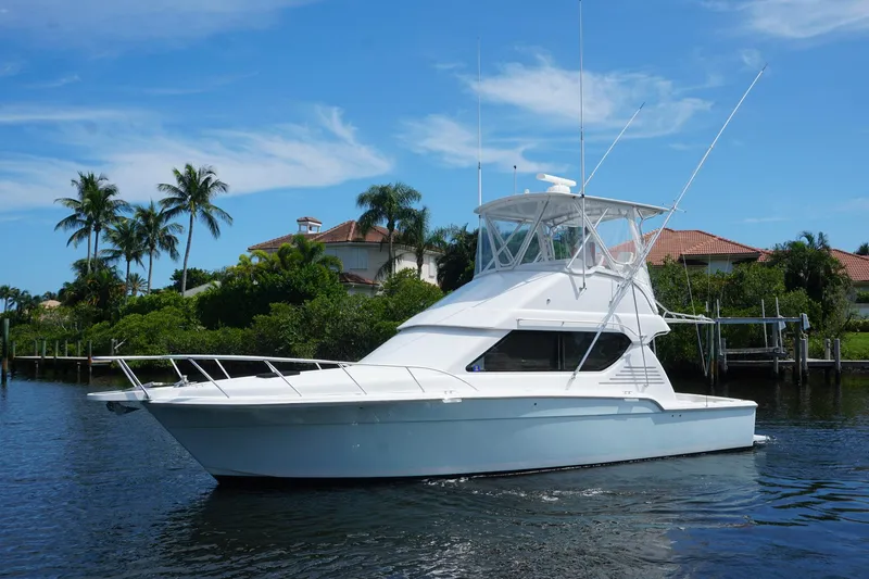 Slide: The Image of 2005 Mirage Yachts 40 Convertible on water, with tropical backdrop and clear blue sky. - 1