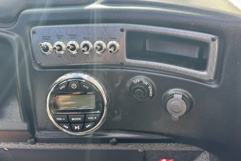 Slide: The Image of Control panel of 2026 Lund 1875 Fisherman boat with switches and audio controls. - 13