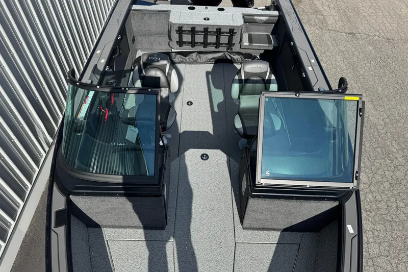 Slide: The Image of 2026 Lund 1875 Fisherman boat interior with seating and windshield, viewed from above. - 4