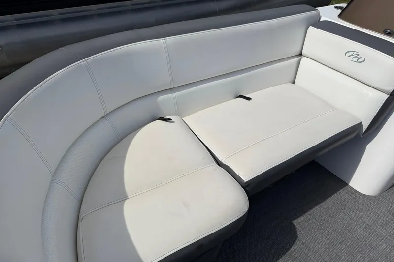 Slide: The Image of 2021 Manitou 22 Aurora LE Standard boat interior with white cushioned seating. - 10
