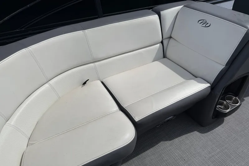 Slide: The Image of 2021 Manitou 22 Aurora LE Standard boat seating with cup holders, featuring white and gray upholstery. - 18