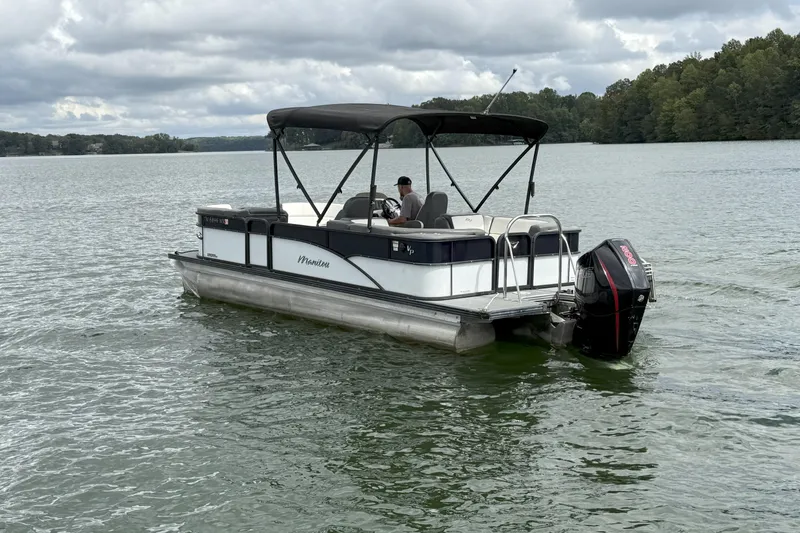 Slide: The Image of 2021 Manitou 22 Aurora LE Standard pontoon boat on a lake under cloudy skies. - 7