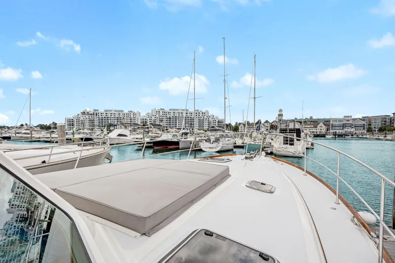 Slide: The Image of 2018 Sabre 48 Salon Express yacht docked in a marina with cityscape background. - 11