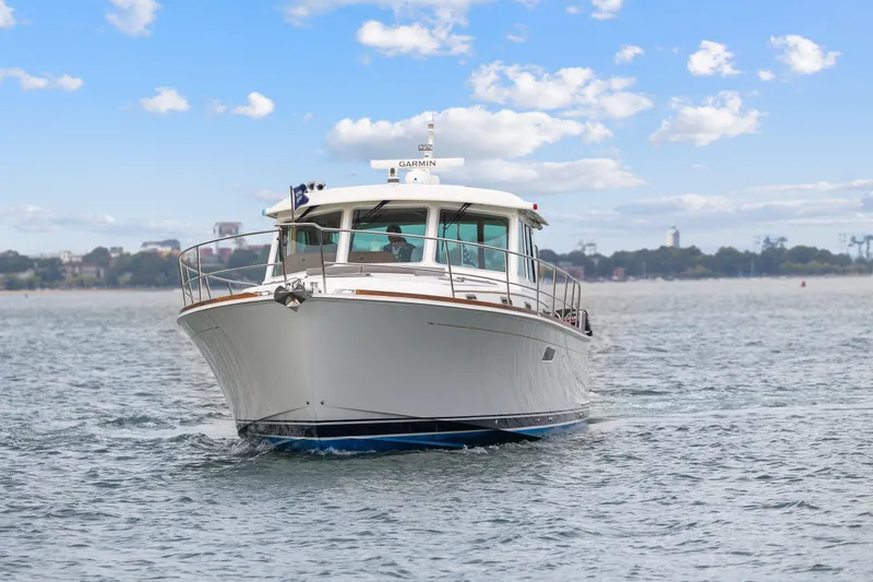 Slide: The Image of 2018 Sabre 48 Salon Express yacht cruising on open water under a blue sky. - 2