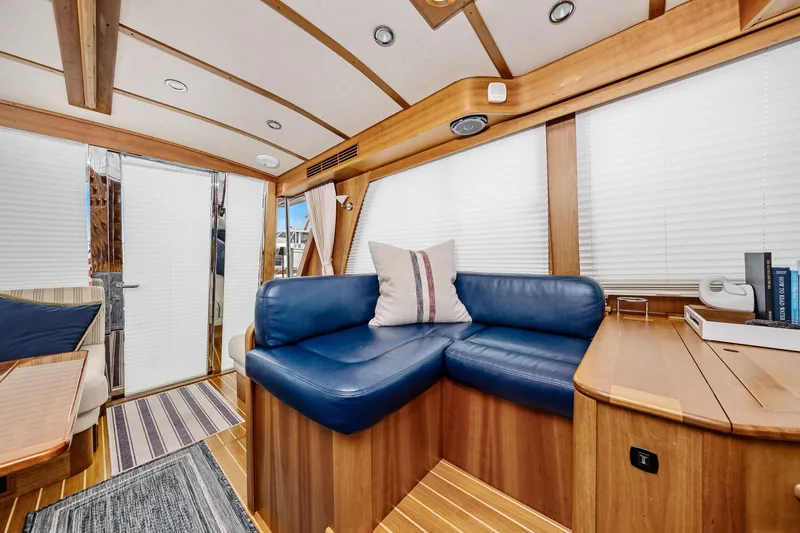 Slide: The Image of 2018 Sabre 48 Salon Express interior with blue leather seating and wooden accents. - 22