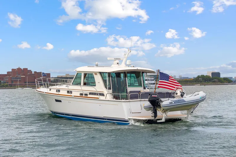 Slide: The Image of 2018 Sabre 48 Salon Express yacht cruising on a sunny day with American flag. - 3