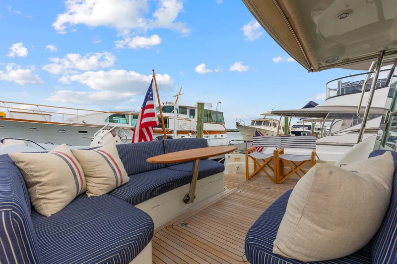 Slide: The Image of 2018 Sabre 48 Salon Express yacht deck with seating, table, and American flag. - 7