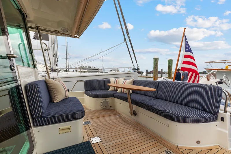 Slide: The Image of 2018 Sabre 48 Salon Express yacht with striped seating and American flag at dock. - 8