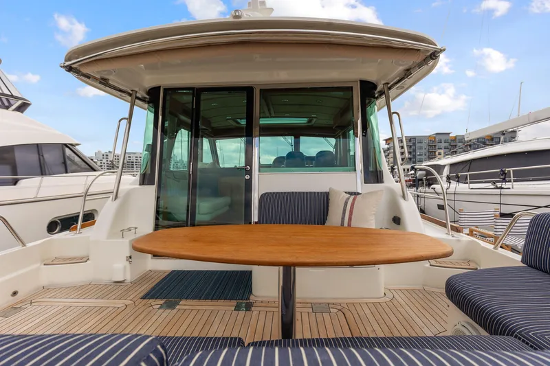 Slide: The Image of 2018 Sabre 48 Salon Express yacht with outdoor seating and wooden table. - 9