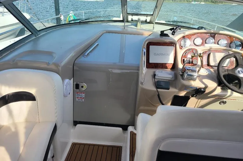 Slide: The Image of 2006 Sea Ray 320 Sundancer helm with Garmin navigation, luxurious seating, and wood accents. - 12