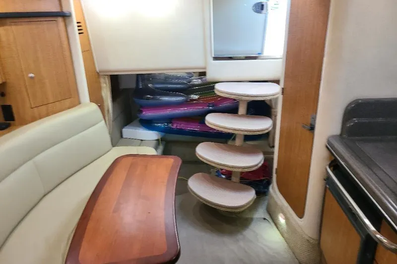 Slide: The Image of Interior of 2006 Sea Ray 320 Sundancer with seating, table, and spiral stairs. - 4