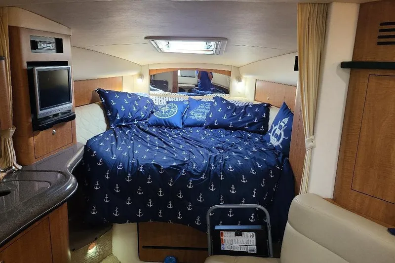 Slide: The Image of Interior cabin of 2006 Sea Ray 320 Sundancer with nautical-themed bedding. - 6