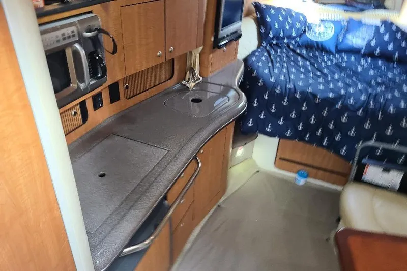 Slide: The Image of Interior of 2006 Sea Ray 320 Sundancer with kitchenette and cozy sleeping area. - 8