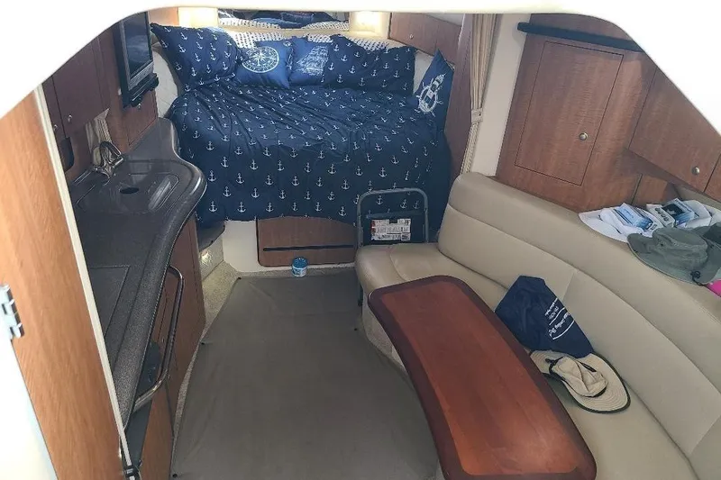 Slide: The Image of Interior of 2006 Sea Ray 320 Sundancer with bed, kitchenette, and seating area. - 9