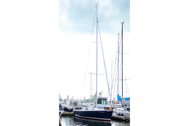 Slide: The Image of Sailboat J/105 from 2000 docked at marina, showcasing tall mast and sleek design. - 16