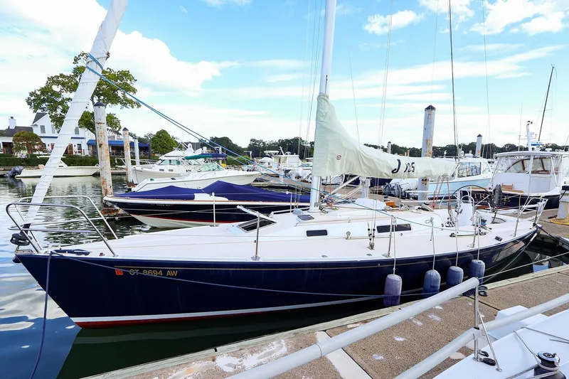 Slide: The Image of 2000 J Boats J/105 sailboat docked at a marina, surrounded by other vessels. - 2