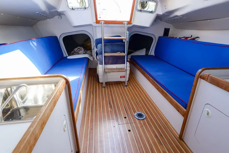 Slide: The Image of Interior of 2000 J Boats J/105 sailboat with blue seating and wooden flooring. - 20
