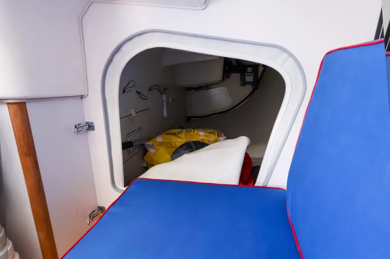 Slide: The Image of Interior storage compartment of a 2000 J Boats J/105 sailboat with blue cushions. - 23