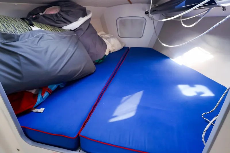 Slide: The Image of Interior cabin of a 2000 J Boats J/105 with blue cushions and bedding. - 26