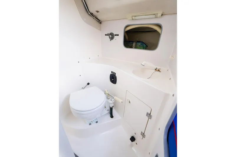 Slide: The Image of Compact marine bathroom in a 2000 J Boats J/105 sailboat, featuring a toilet and sink. - 28