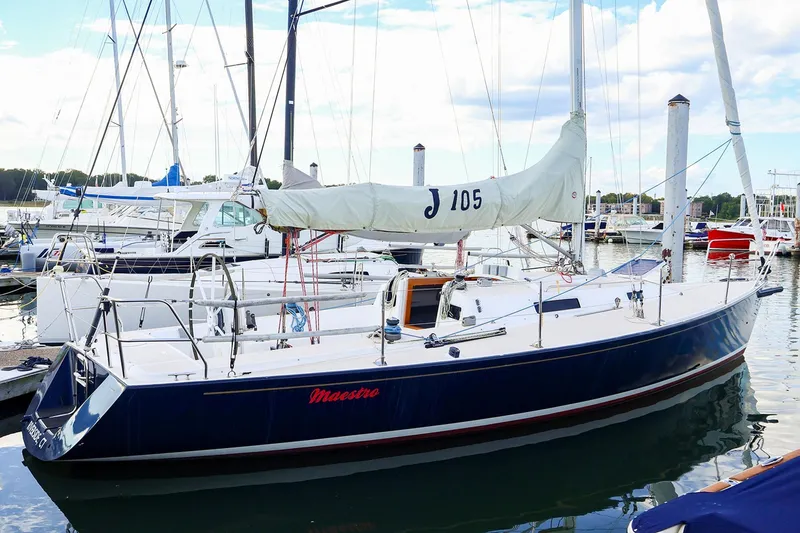 Slide: The Image of 2000 J Boats J/105 sailboat docked in marina, featuring sleek design and white sails. - 29