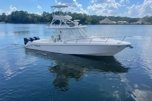 Slide: The Image of 2011 Everglades 350LX boat on calm lake with clear sky and trees in background. - 10