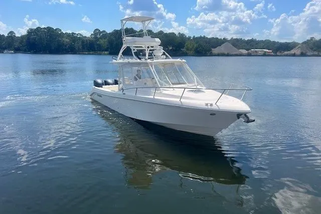 Slide: The Image of 2011 Everglades 350LX boat cruising on a calm lake under a clear blue sky. - 11