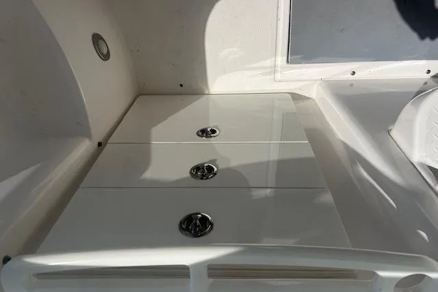 Slide: The Image of 2011 Everglades 350LX boat storage compartment with three chrome handles. - 19