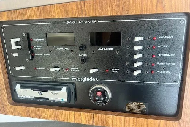 Slide: The Image of Control panel of a 2011 Everglades 350LX boat, featuring 120V AC system switches. - 24