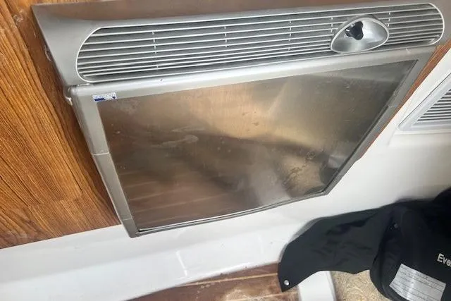 Slide: The Image of 2011 Everglades 350LX interior with stainless steel appliance and wooden paneling. - 26