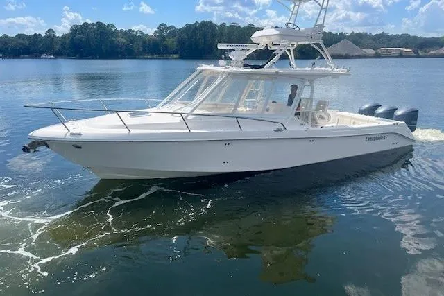 Slide: The Image of 2011 Everglades 350LX boat cruising on a calm lake under a clear blue sky. - 3