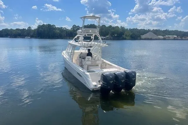 Slide: The Image of 2011 Everglades 350LX boat with triple outboard engines on a calm lake. - 6