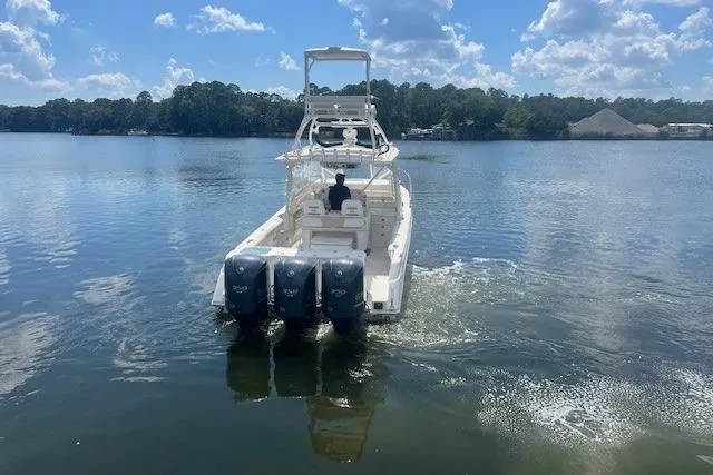 Slide: The Image of 2011 Everglades 350LX boat cruising on a calm lake under a blue sky. - 7